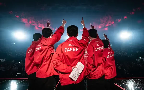 HD PC wallpaper featuring T1 esports team members from League of Legends, with Faker prominently centered in their signature red jackets under bright arena lights.