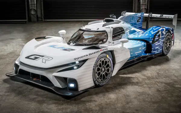 Sleek Toyota race car with aerodynamic design, captured in 8K Ultra HD, showcasing advanced performance and striking blue-white color scheme on a concrete floor.