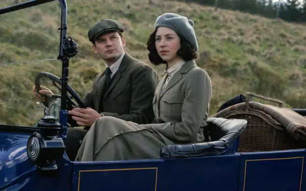 HD desktop wallpaper featuring a scene from the TV show Outlander: Blood of My Blood, depicting two characters dressed in period attire seated in a vintage car.