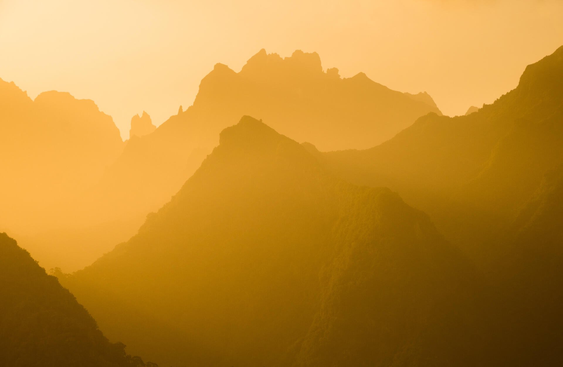 Yellow-hued mountain silhouettes layered in sunlight, serene landscape rendered as 5K Ultra HD PC desktop wallpaper and background.