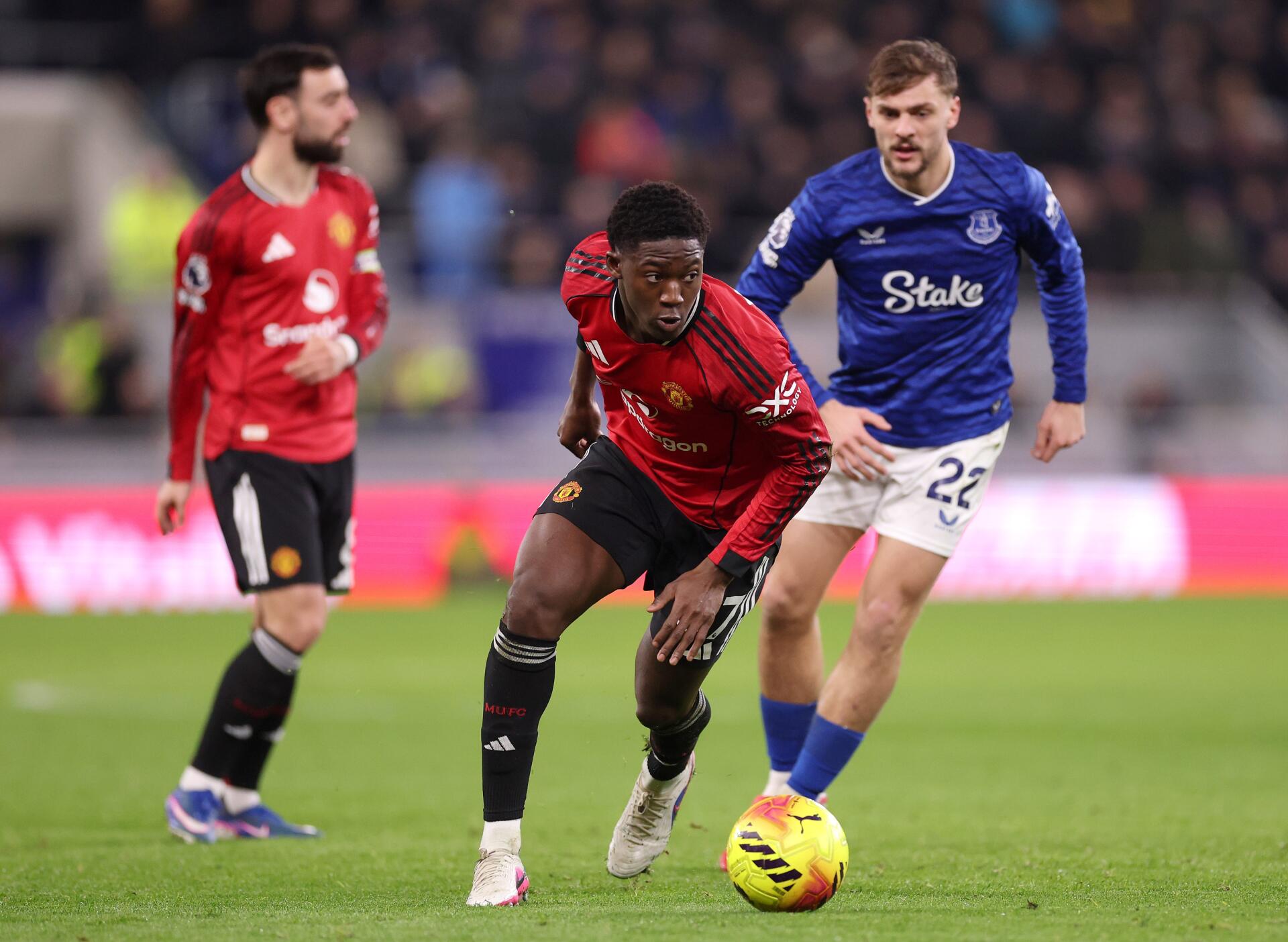 Premier League soccer action: Manchester United player in red dribbling past an Everton opponent on the pitch — 4K Ultra HD PC desktop wallpaper background.