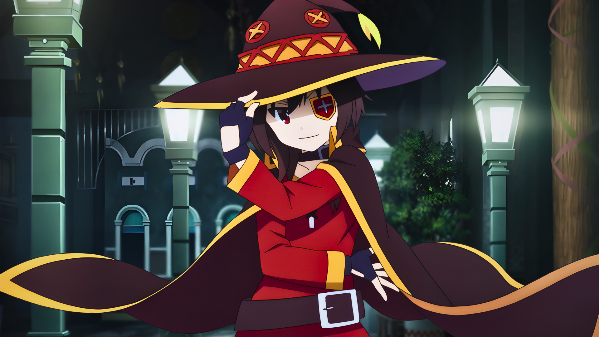 Megumin (KonoSuba), cute anime mage in a red cloak and oversized hat, posing playfully on a lamplit night street — 4K Ultra HD PC desktop wallpaper.