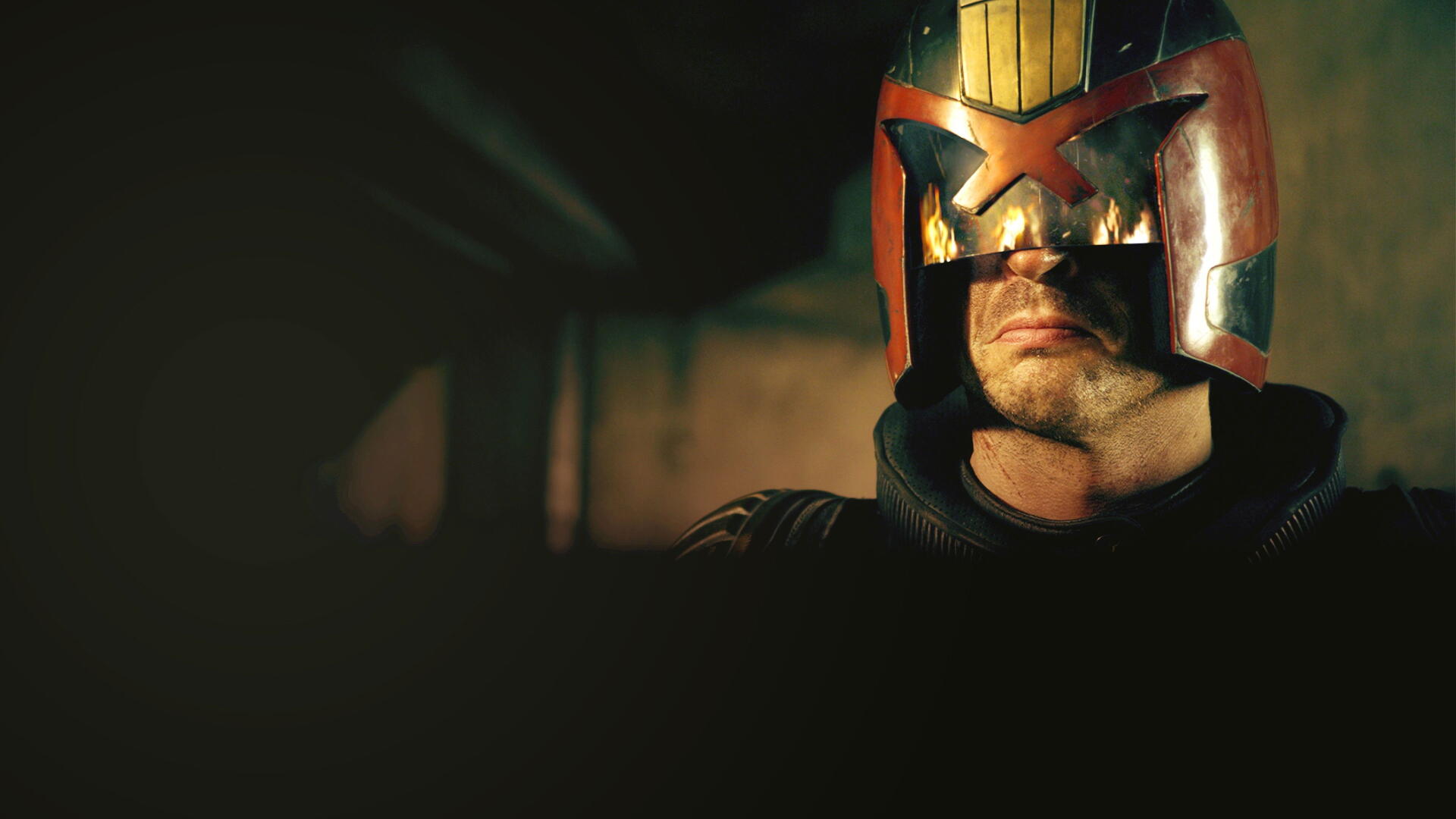 Dredd helmet close-up in low light, visor glinting and jaw set — gritty 4K Ultra HD PC desktop wallpaper and background.