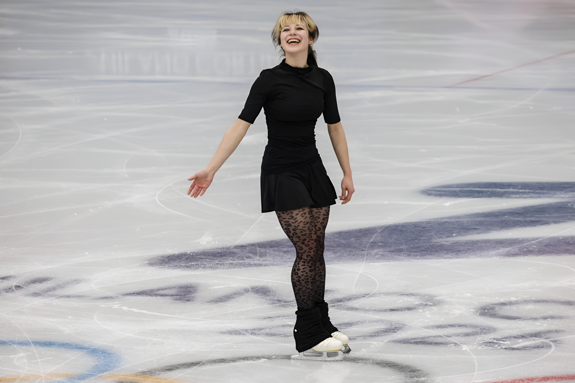 4K Ultra HD PC desktop wallpaper of a female figure skater in a black dress, smiling and gliding across the ice during a sports performance.
