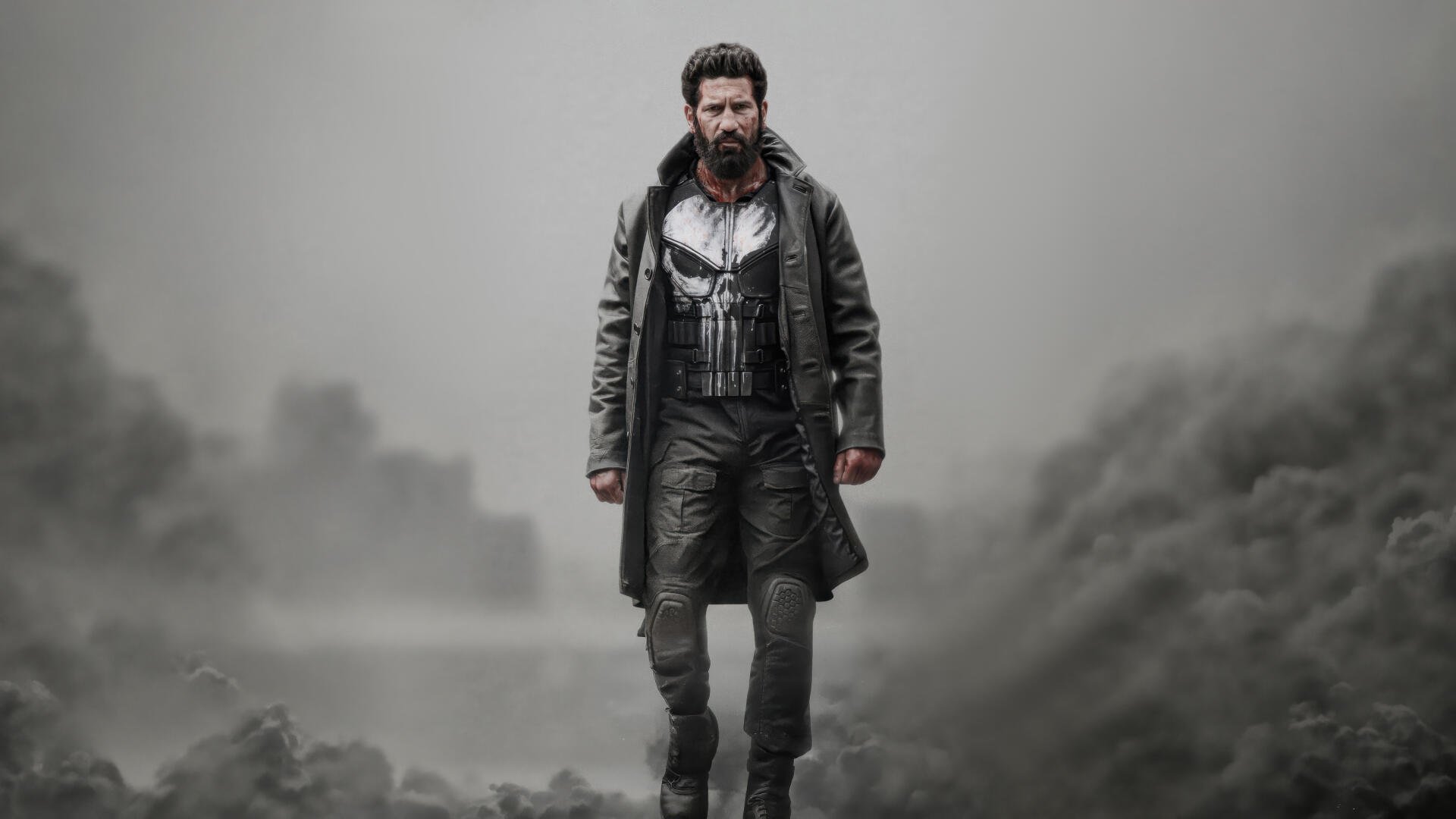 The Punisher: One Last Kill — bearded vigilante in skull chest armor and long coat walks through foggy, ruined city. 5K Ultra HD PC desktop wallpaper and background.