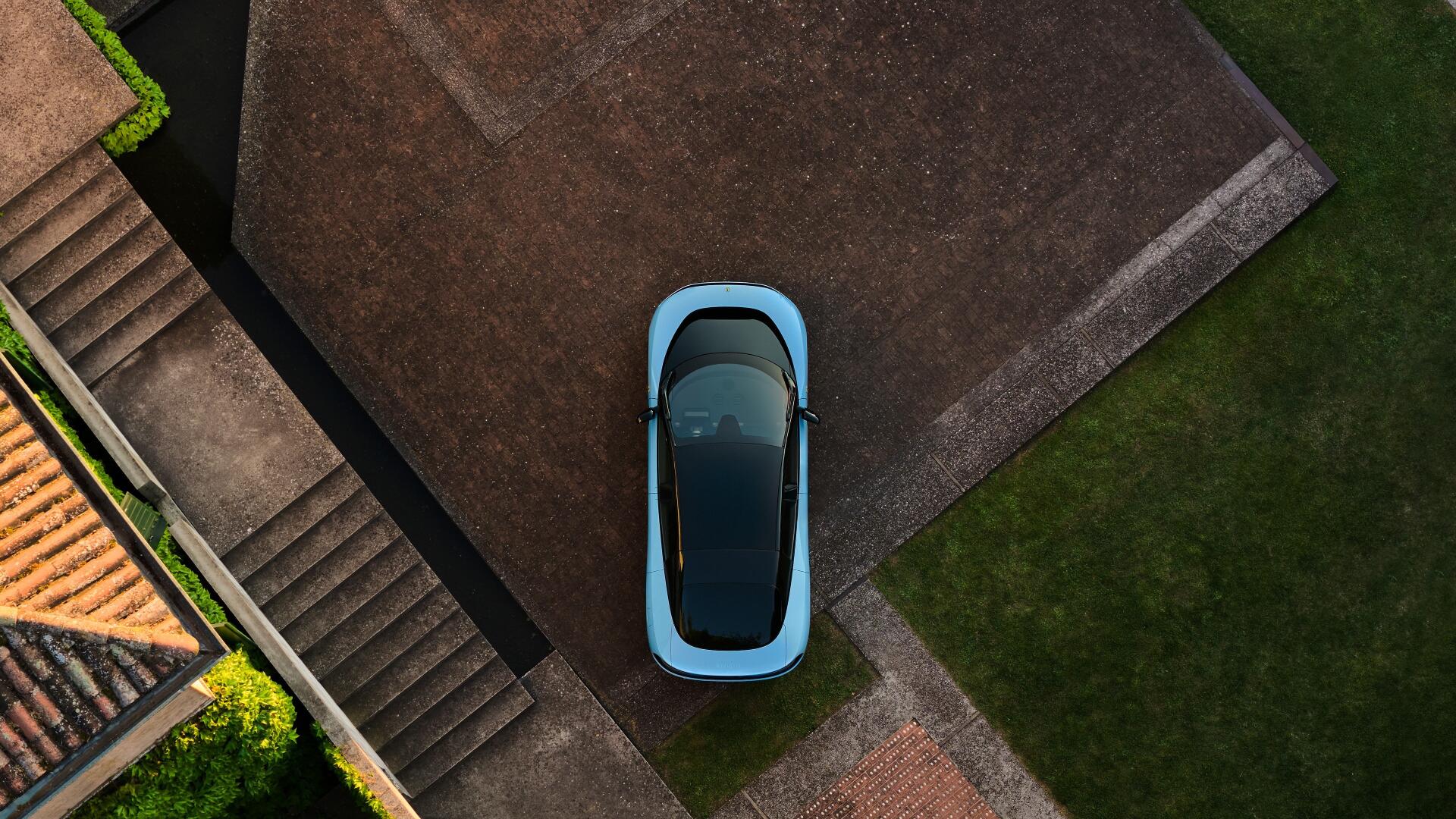 Aerial view of a light-blue Ferrari Luce vehicle parked on a modern driveway, 4K Ultra HD PC desktop wallpaper background.