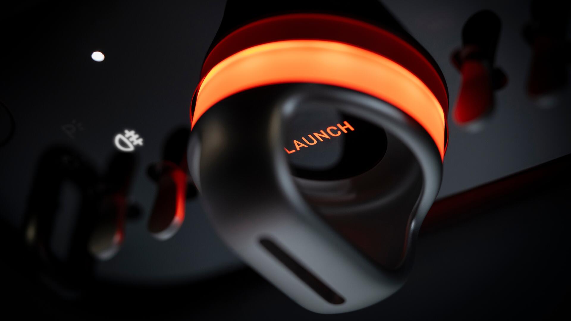 4K Ultra HD PC wallpaper: close-up of glowing orange LAUNCH knob in a Ferrari Luce vehicle cockpit.
