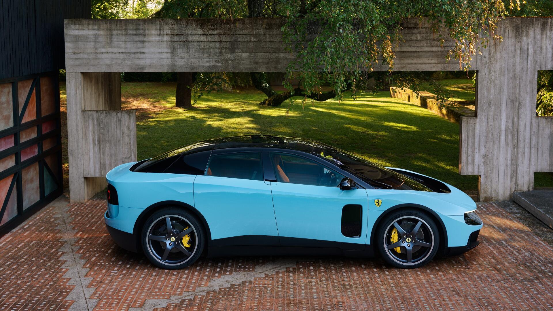 Side profile of a light-blue Ferrari Luce parked beneath a concrete overhang on a brick driveway with sunlit lawn behind — 4K Ultra HD PC desktop wallpaper.