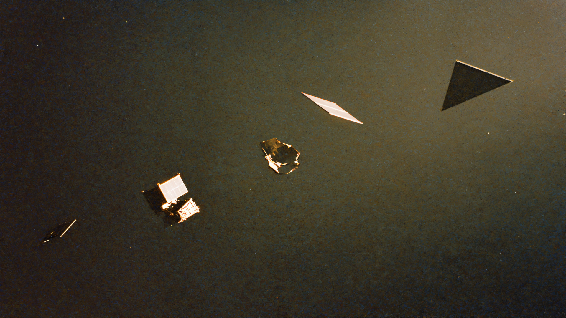 4K Ultra HD PC desktop wallpaper of space debris: metallic panels and fragments drifting against a deep, muted space backdrop.