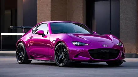 Vibrant purple Mazda sports coupe with black alloy wheels and rear wing parked by a modern building — 4K Ultra HD PC desktop wallpaper/background.