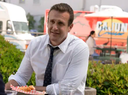 Man in white shirt and tie sits at an outdoor table, smiling; 4K Ultra HD PC desktop wallpaper for the TV show Shrinking.