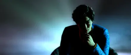 Moody 4K Ultra HD wallpaper of a Yakuza from Like a Dragon Gaiden: The Man Who Erased His Name, silhouetted in high-contrast light with drifting smoke, contemplative pose against a blue backdrop.