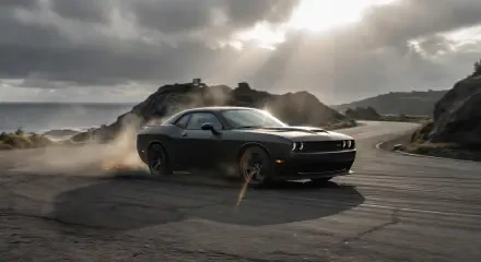 Black Dodge Challenger drifting on a coastal road, kicking up smoke beneath dramatic clouds — 2K Quad HD PC desktop wallpaper/background.
