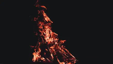 5K Ultra HD PC desktop wallpaper: vivid orange fire and dancing flames rising from a black, shadowed background.