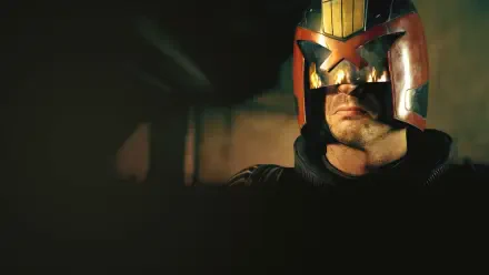 Dredd helmet close-up in low light, visor glinting and jaw set — gritty 4K Ultra HD PC desktop wallpaper and background.