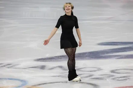 4K Ultra HD PC desktop wallpaper of a female figure skater in a black dress, smiling and gliding across the ice during a sports performance.