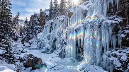 5K Ultra HD PC desktop wallpaper and background: a frozen waterfall with sculpted ice curtains and snow-covered rocks bathed in cold blue light.