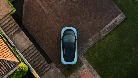 Aerial view of a light-blue Ferrari Luce vehicle parked on a modern driveway, 4K Ultra HD PC desktop wallpaper background.
