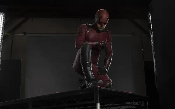 Daredevil: Born Again TV show HD PC desktop wallpaper — Daredevil in red suit kneeling on a rooftop under studio lights against a dark backdrop.