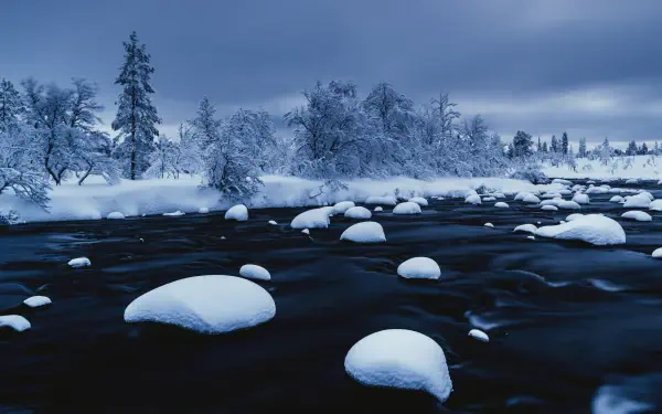 HDR 4K Ultra HD photography of a snowy landscape: ice-covered rocks on a frozen lake beneath a moody sky, a PC desktop wallpaper background.