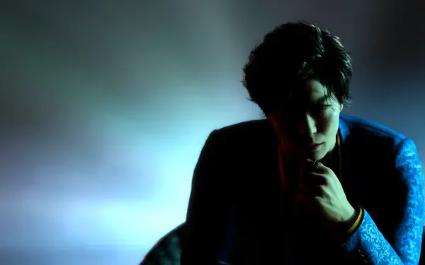 Moody 4K Ultra HD wallpaper of a Yakuza from Like a Dragon Gaiden: The Man Who Erased His Name, silhouetted in high-contrast light with drifting smoke, contemplative pose against a blue backdrop.