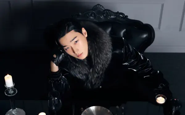 K-pop ATEEZ-inspired black 4K desktop wallpaper: solitary figure in glossy black coat with fur collar reclining at a candlelit table, moody high-contrast portrait.