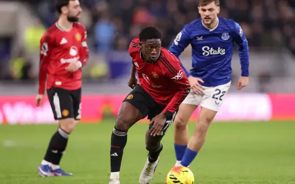 Premier League soccer action: Manchester United player in red dribbling past an Everton opponent on the pitch — 4K Ultra HD PC desktop wallpaper background.