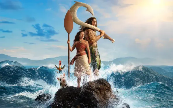 Moana (Live Action) and Maui stand on a rocky outcrop as waves crash beneath a sunlit sky — 5K Ultra HD PC desktop wallpaper and background