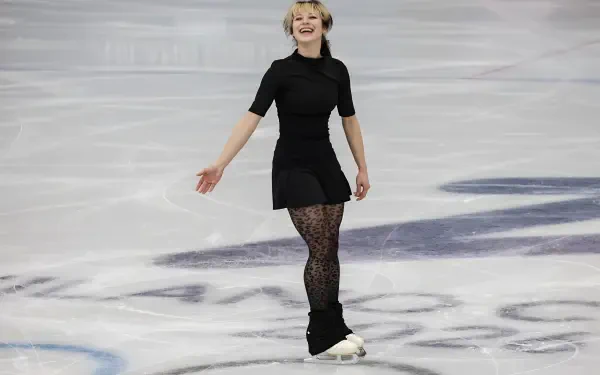 4K Ultra HD PC desktop wallpaper of a female figure skater in a black dress, smiling and gliding across the ice during a sports performance.