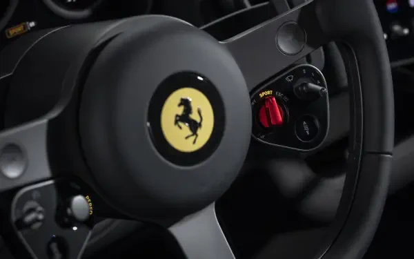 Close-up of Ferrari steering wheel with prancing horse emblem and red drive-mode switch, 4K Ultra HD PC desktop wallpaper showcasing the Ferrari Luce vehicle interior.