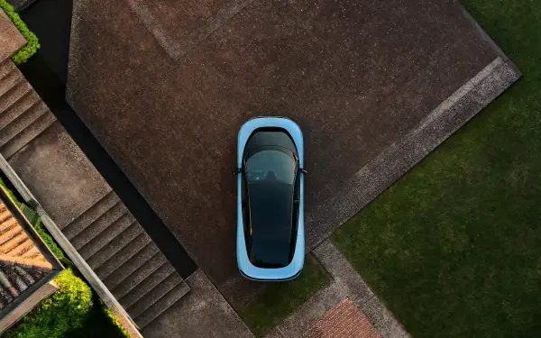 Aerial view of a light-blue Ferrari Luce vehicle parked on a modern driveway, 4K Ultra HD PC desktop wallpaper background.