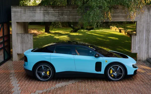 Side profile of a light-blue Ferrari Luce parked beneath a concrete overhang on a brick driveway with sunlit lawn behind — 4K Ultra HD PC desktop wallpaper.