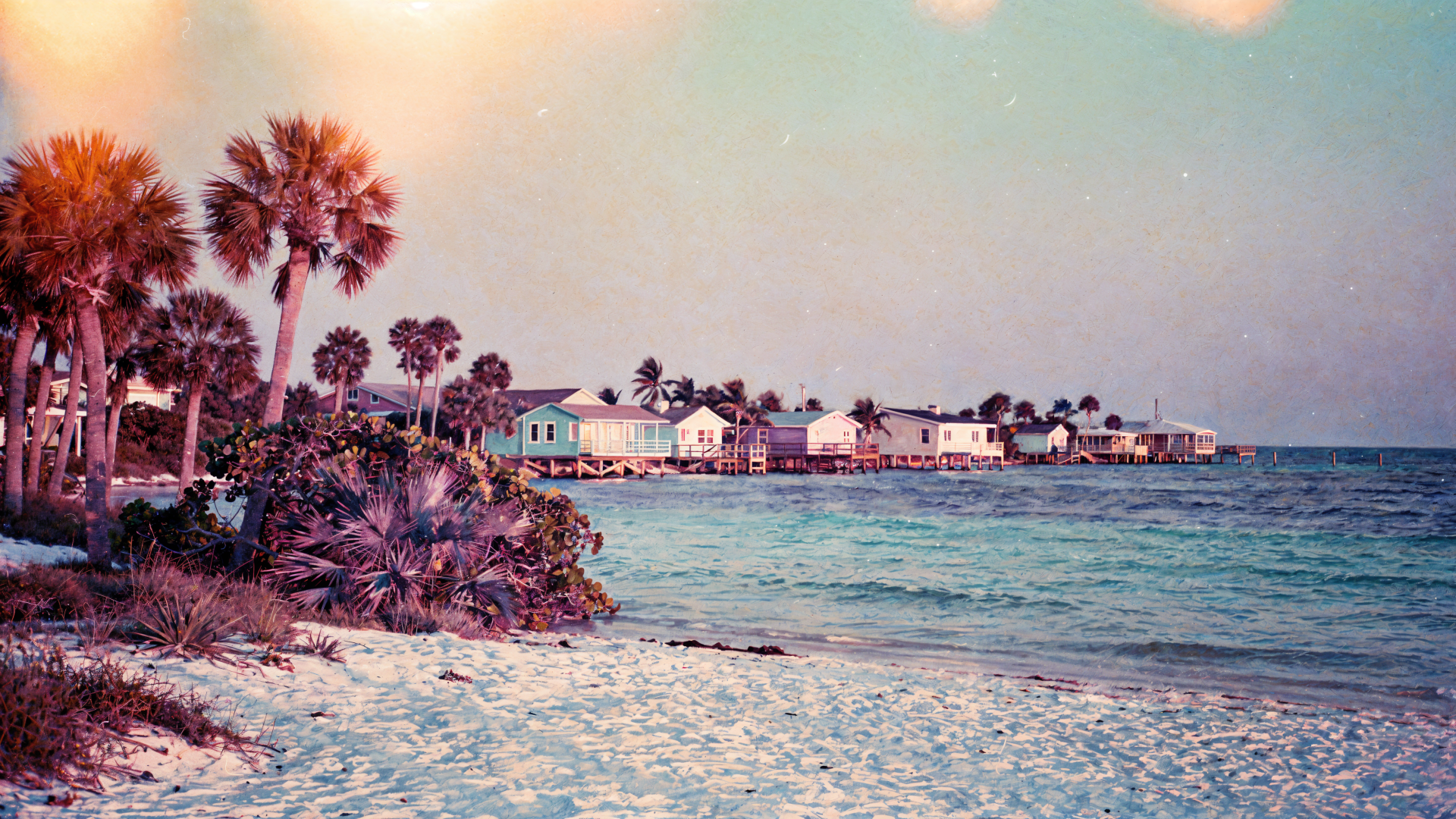 Florida beach at sunrise with palms, pastel sky and turquoise water, coastal cottages on the horizon — 4K Ultra HD PC desktop wallpaper and background.