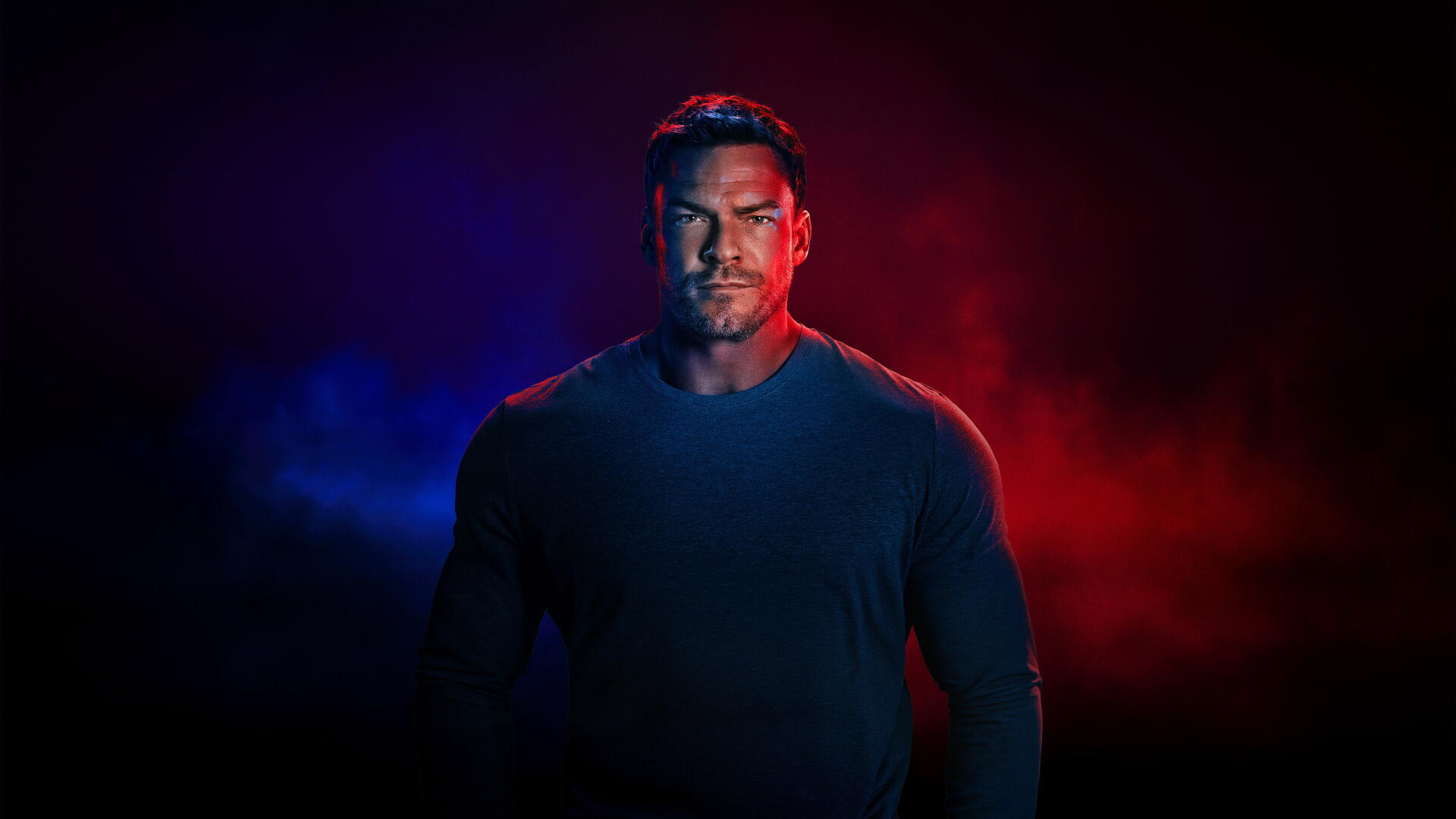 Reacher portrait under red and blue cinematic lighting, intense stare and shadowed muscles against a dark backdrop — 4K Ultra HD PC desktop wallpaper and background.