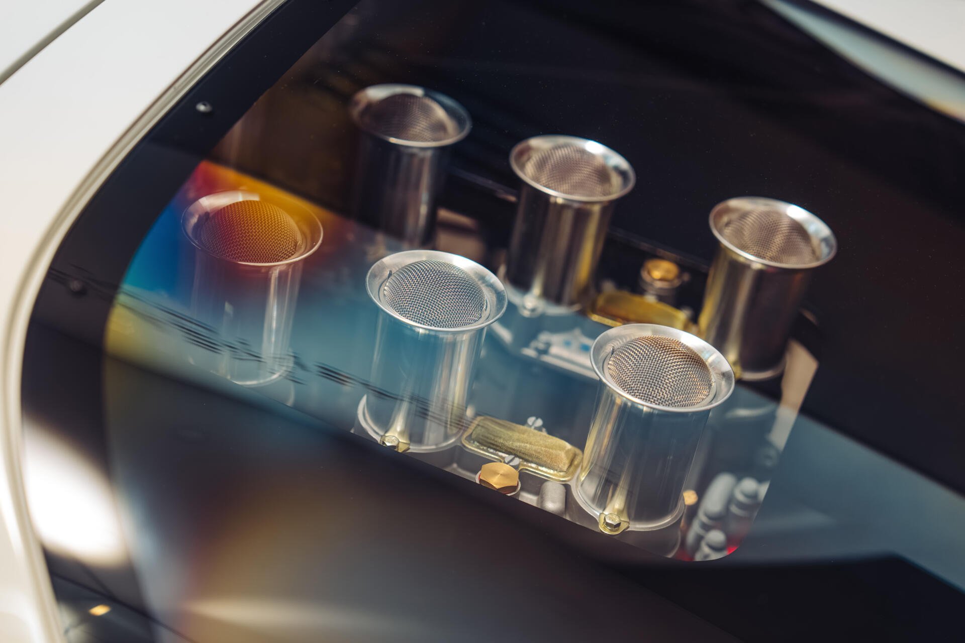Close-up of polished intake trumpets on a McLaren G6GT engine, vivid reflections and fine detail — 8K Ultra HD PC desktop wallpaper background showcasing McLaren vehicle craftsmanship.