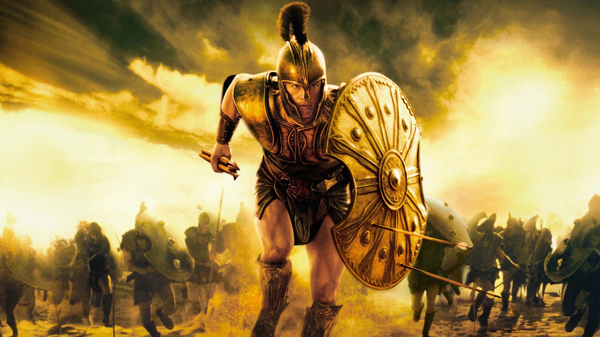 Troy-themed 4K Ultra HD PC desktop wallpaper: armored Trojan warrior charging with shield raised amid a smoky battlefield under golden light.