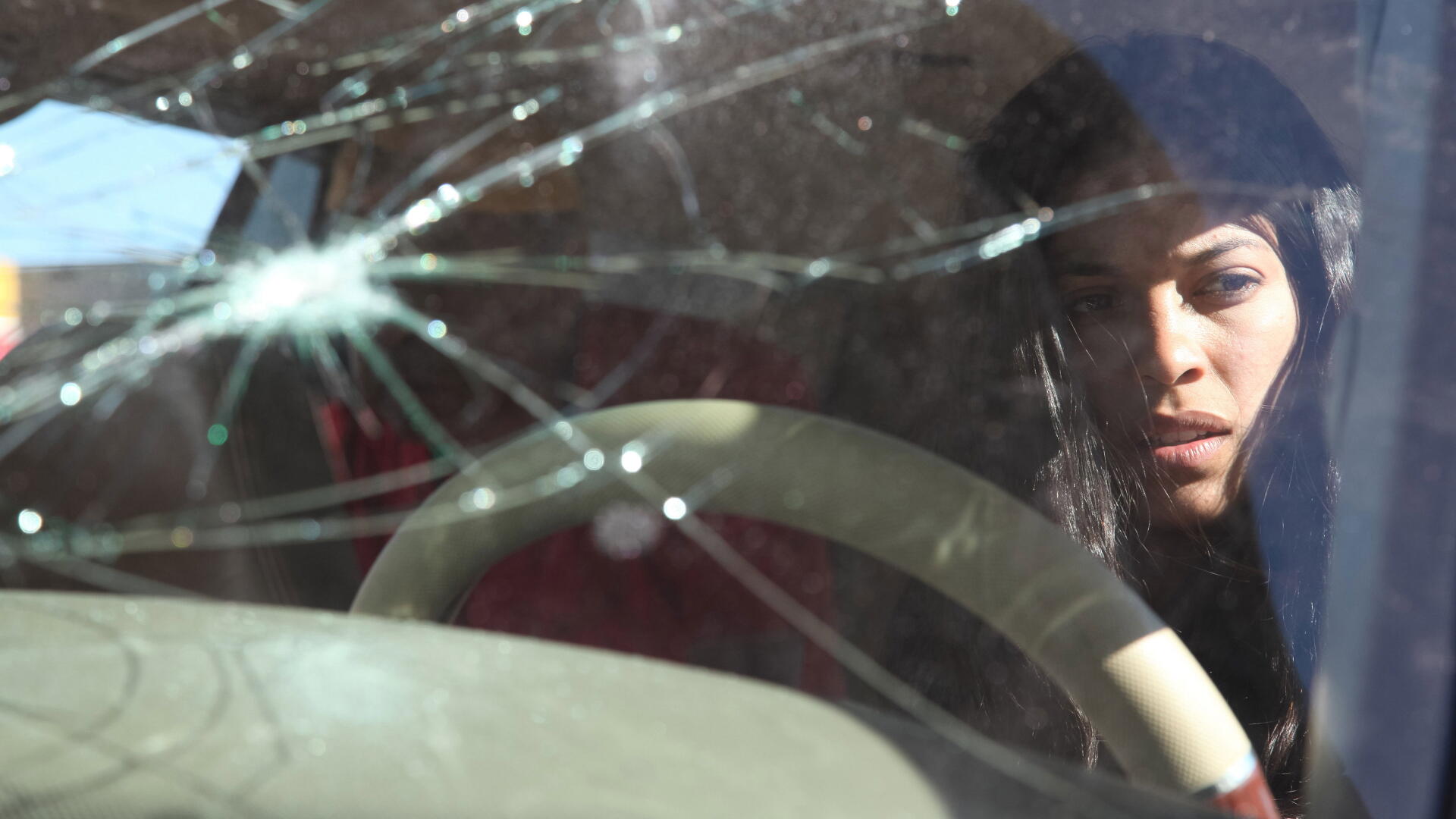 Close-up of a woman behind a cracked windshield, brooding cinematic shot from Miss Bala — 4K Ultra HD PC desktop wallpaper and background.
