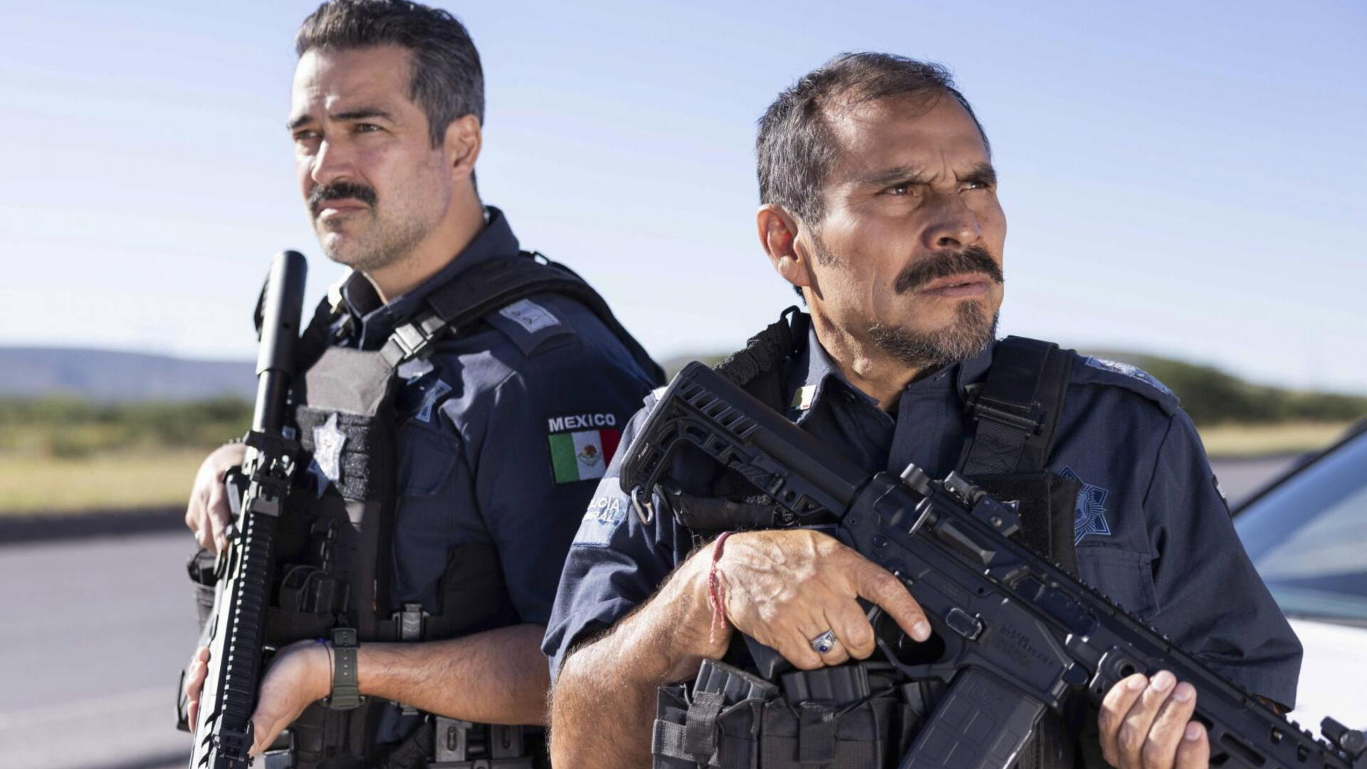 4K Ultra HD PC wallpaper titled Facing El Chapo — two armed Mexican officers in tactical gear stand alert by a roadside under a clear blue sky.