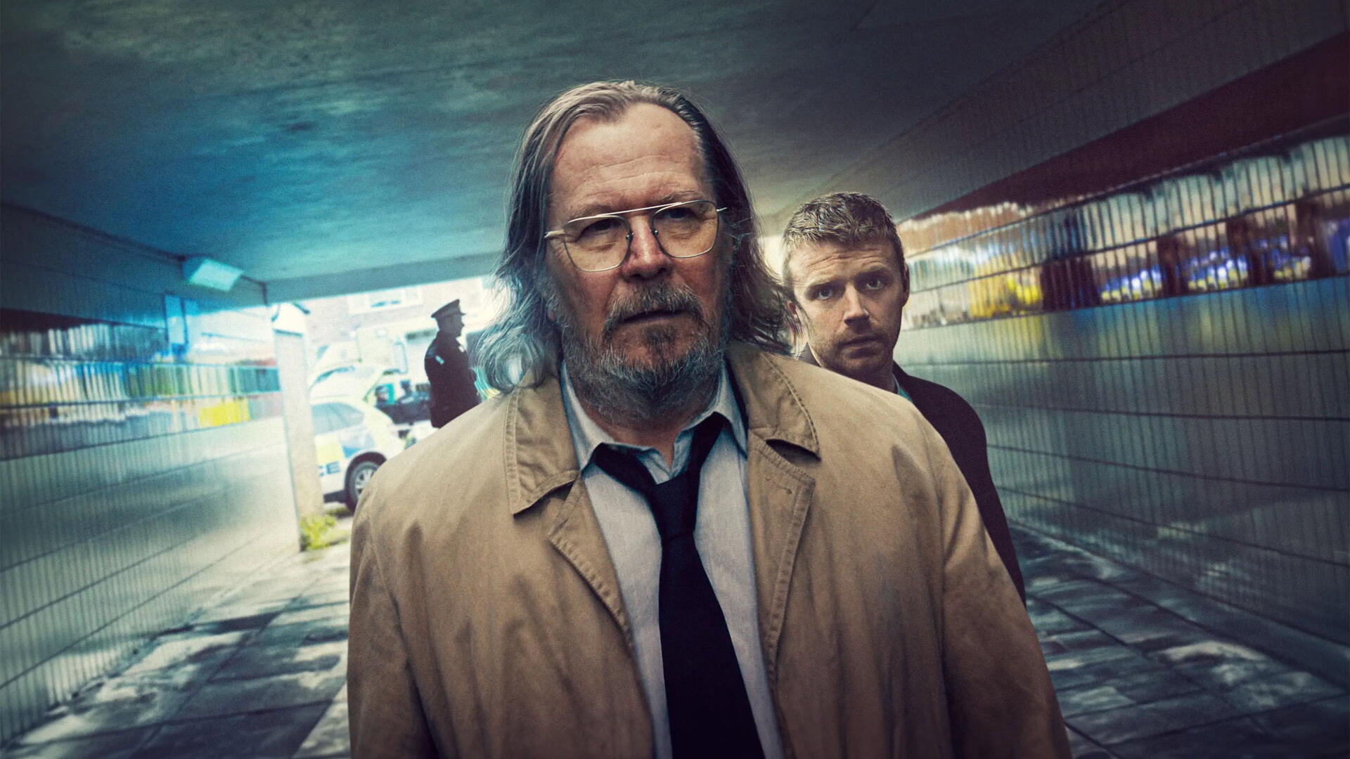 4K Ultra HD PC desktop wallpaper of two weary figures in trench coats in a rain‑slick tiled underpass, moody blue‑green lighting and neon reflections — Slow Horses.