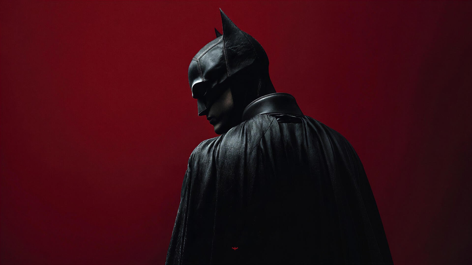 Moody digital art of Batman in cape and cowl against a deep red background — 4K Ultra HD superhero PC desktop wallpaper and background.