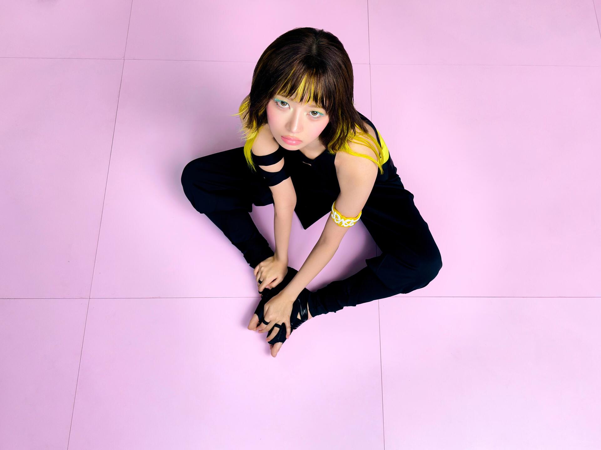IVE Rei model in a black and yellow outfit against a pink backdrop, featured in Looks Can Kill 4K Ultra HD desktop wallpaper.