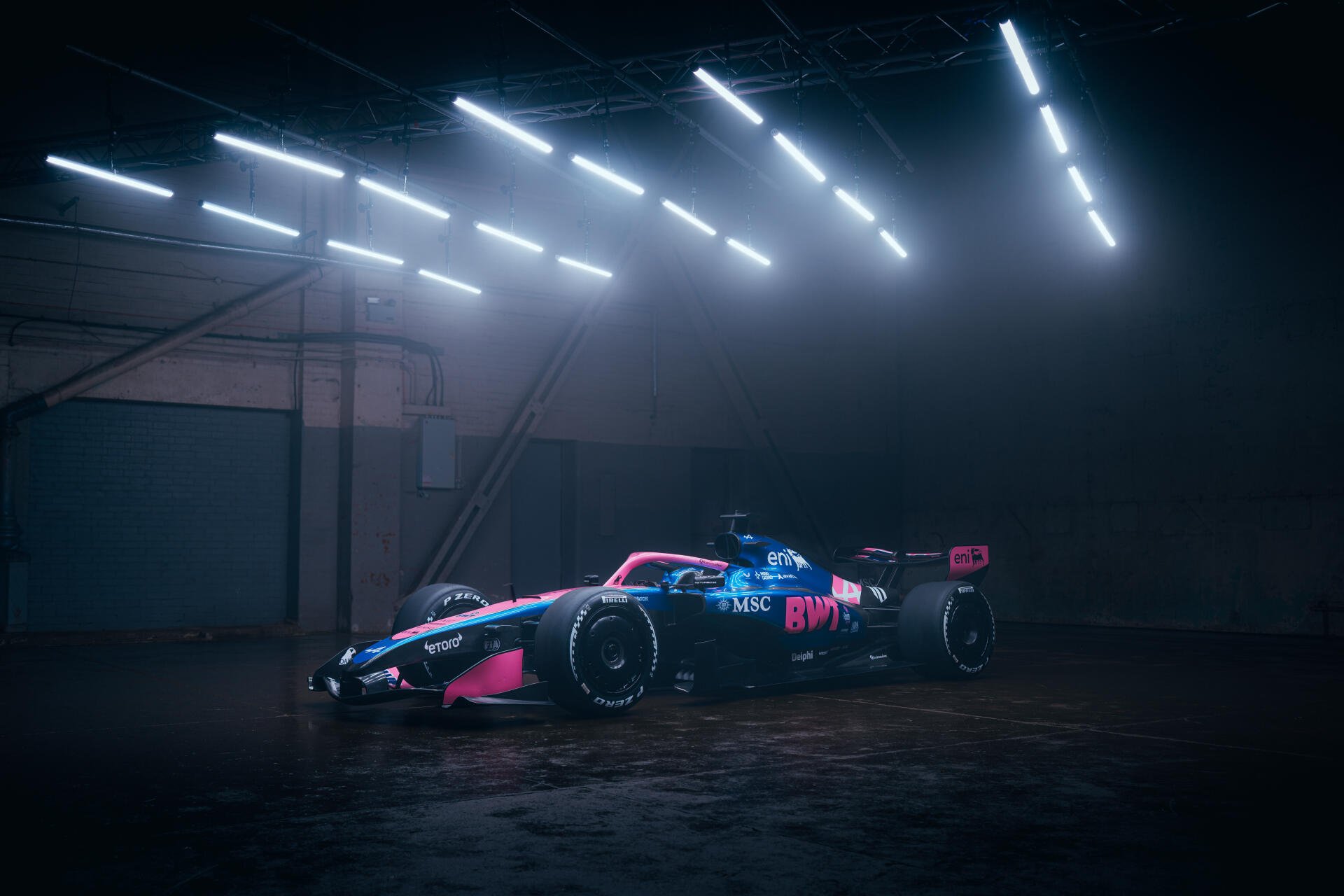 Alpine A526 F1 race car in a dramatic, misty garage, featured in an 8K Ultra HD PC desktop wallpaper.