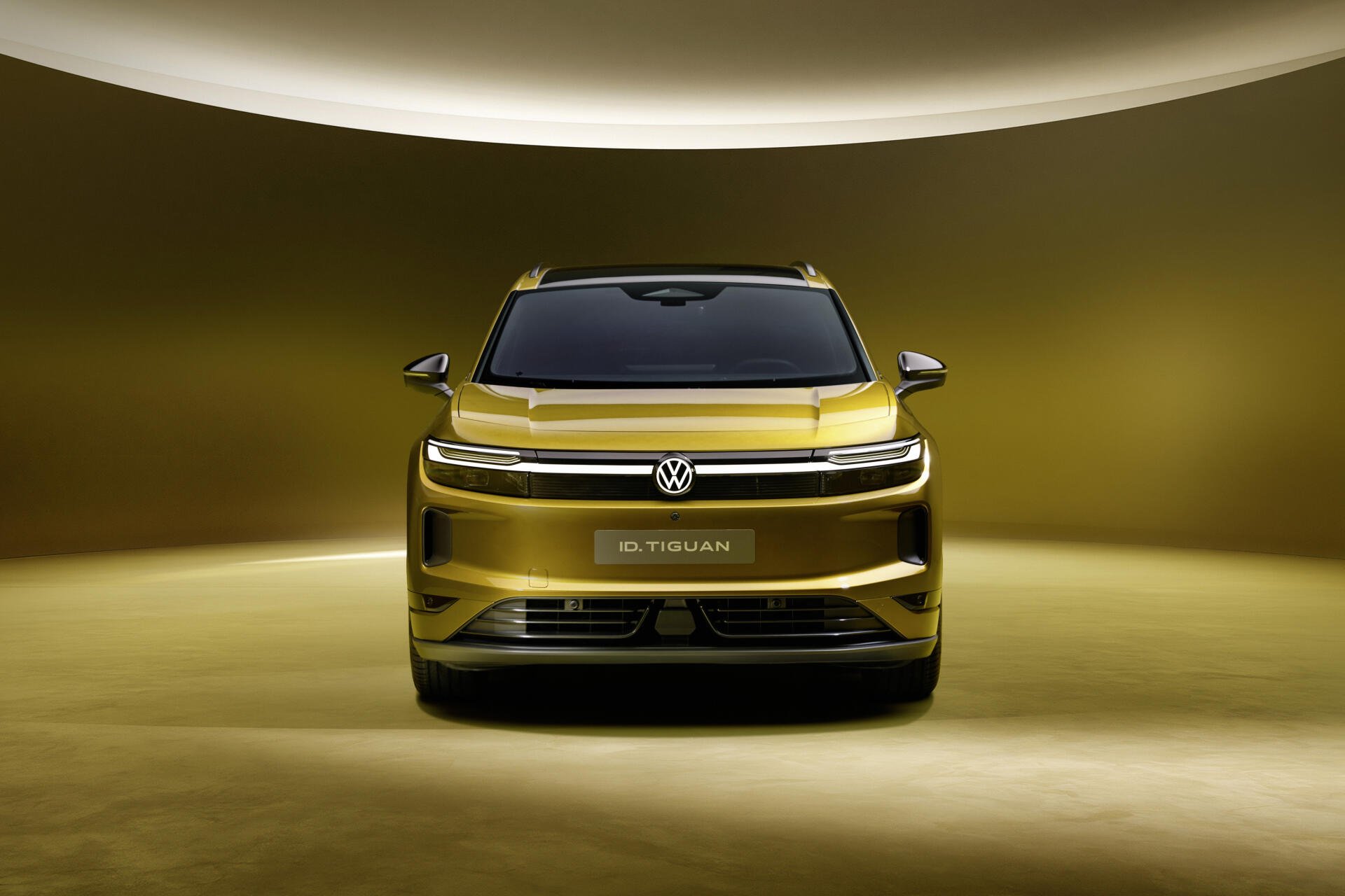 Front view of a gold Volkswagen ID. Tiguan SUV in a dramatic studio, 4K Ultra HD PC desktop wallpaper and background.