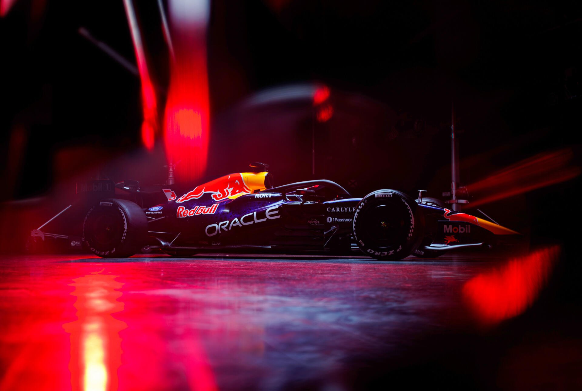 Red Bull Racing RB22 F1 race car under dramatic red lights, 4K Ultra HD PC desktop wallpaper and background.