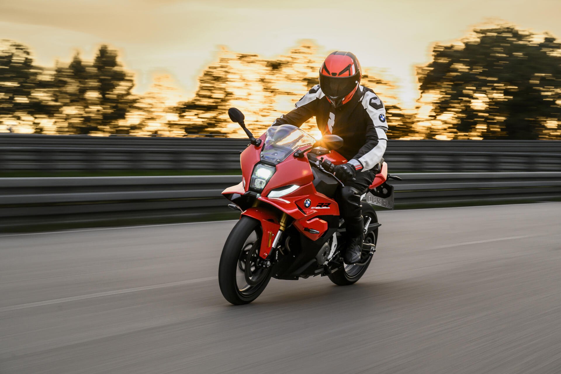 BMW Motorrad F 450 RR sport motorcycle ridden on a road at sunset, featured in a 5K Ultra HD desktop wallpaper.