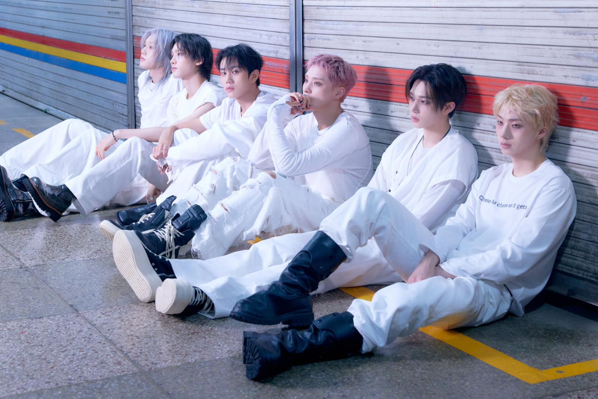 P1Harmony boy band members in white outfits seated by a colorful wall, featured in BLOW UP 4K Ultra HD PC desktop wallpaper.