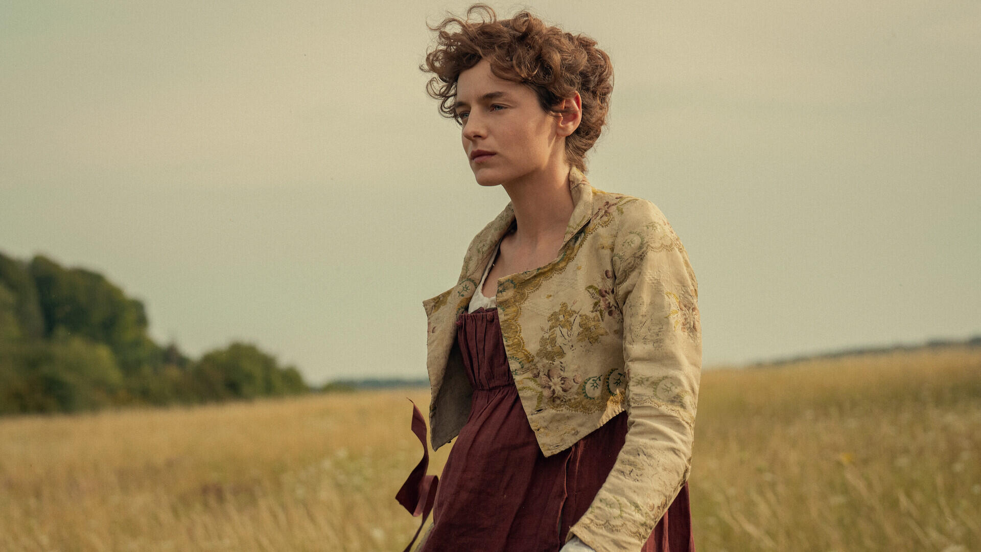 Emma Corrin in a period dress in a golden field from Netflix’s Pride and Prejudice (2026), HD desktop wallpaper.