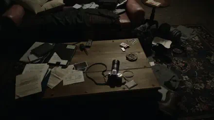 4K Ultra HD PC video game wallpaper: dim living room with a cluttered coffee table — scattered papers, a camera and ashtray — moody scene tied to Resident Evil Veronica (Resident Evil).