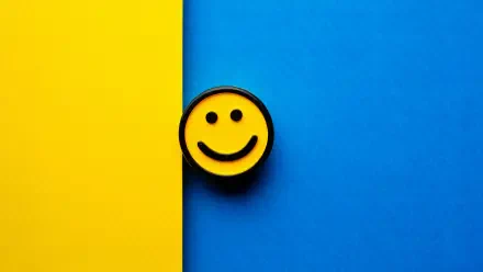 Smiley face badge centered on a vertical split yellow and blue field — 5K Ultra HD PC desktop wallpaper and background.