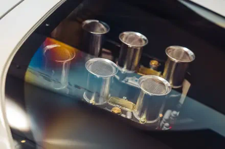 Close-up of polished intake trumpets on a McLaren G6GT engine, vivid reflections and fine detail — 8K Ultra HD PC desktop wallpaper background showcasing McLaren vehicle craftsmanship.